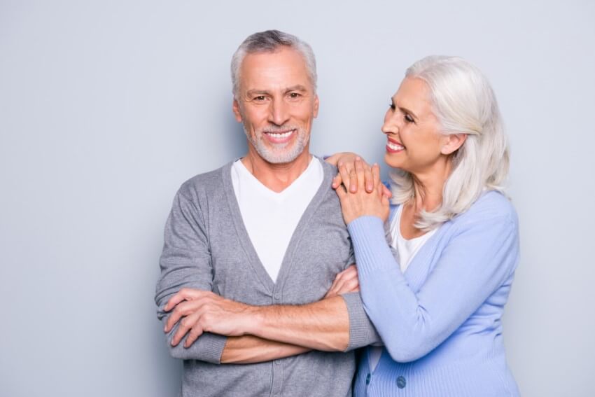 happy mature couple with silver hair smiling at each other