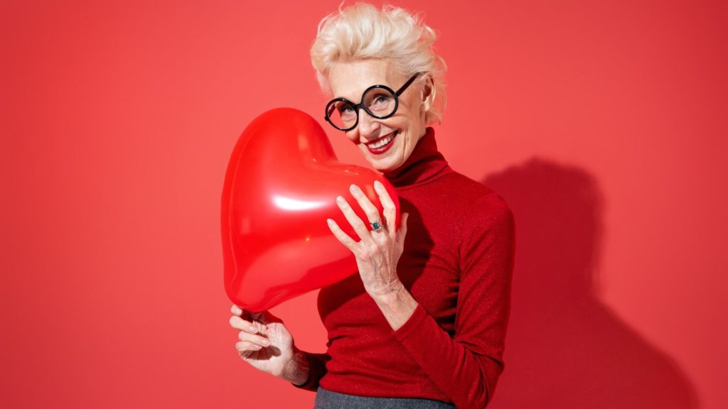 Attractive granny holds heart balloon