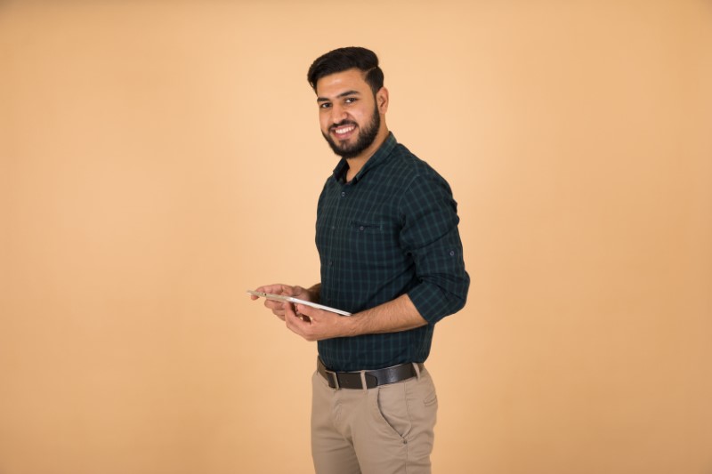 handsome muslim man visits online dating sites on his tablet
