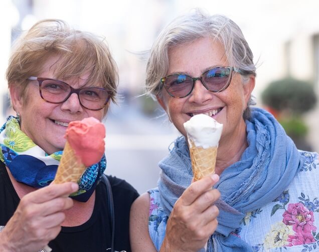 Two older lesbians enjoying ice cream together. 